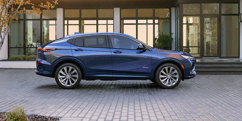 A blue 2024 Buick Envista parked in from of a modern home