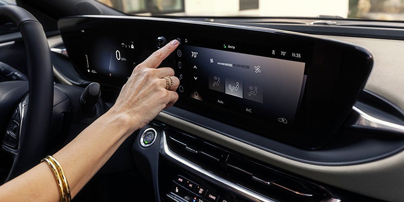 Interior view of the 2024 Buick Envista with a woman interacting with the touch-screen console
