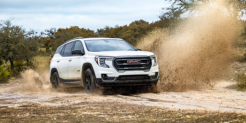 2024 GMC Terrain driving through a muddy road