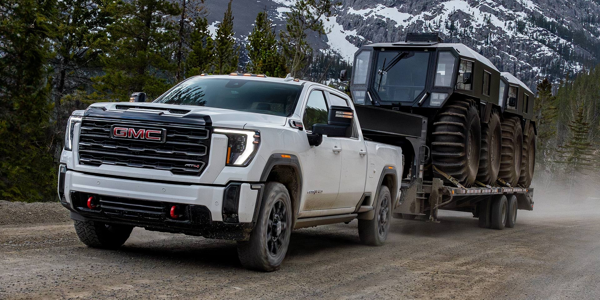 White 2026 GMC Sierra 3500 driving in mountain terrain