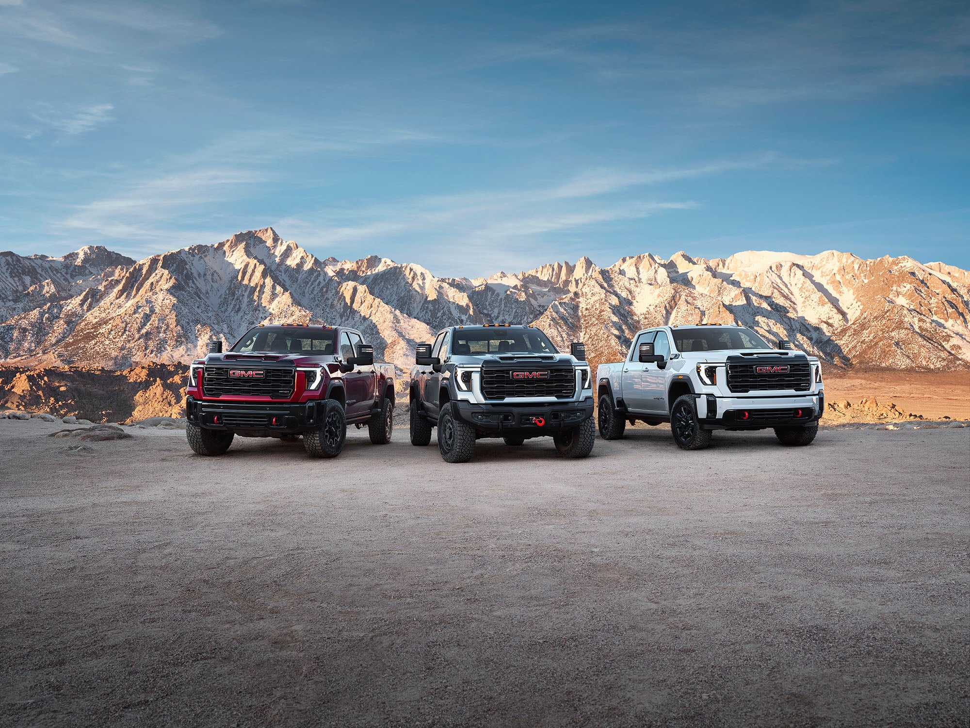 2026 GMC Sierra 1500 trim level comparison with 3 of vehicles parked infornt of mountians.