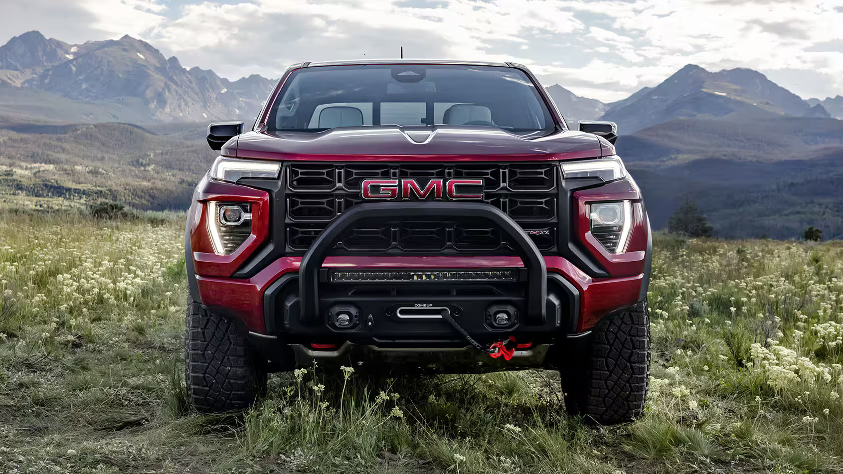 2026 GMC Canyon front grill view on grassy hill.