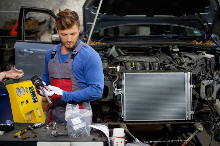 McGuire technician performing maintenance inside a professional workshop, with tools and equipment in the background.
