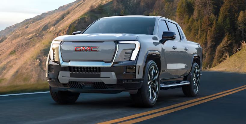 2026 Silver GMC Sierra truck driving on a mountain road near McGuire Buick GMC in Little Falls, NJ.