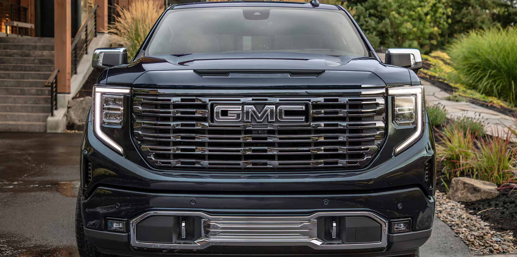 The front grill view of a 2026 GMC Denali truck parked in front of home.