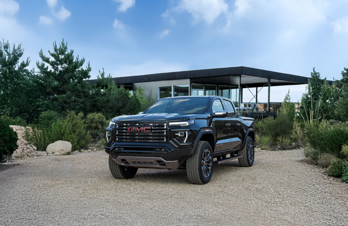 2026 GMC Canyon parked on gravel outside of modern home.
